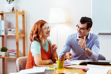 Pleasant communication. Joyful young people talking to each other while studying togetherの写真素材