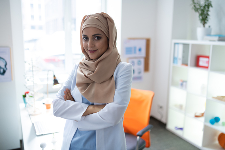 Appealing chemist. Pleasant appealing female chemist wearing uniform feeling good after workingの写真素材