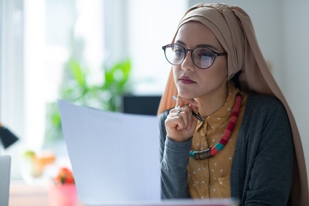 Young woman. Beautiful young woman wearing hijab and glasses feeling tired after workingの写真素材