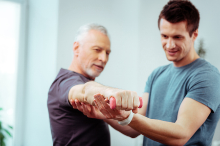 Development of muscles. Selective focus of a male hand with a small dumbbell in itの写真素材