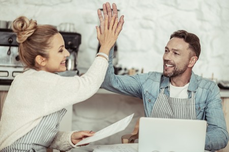 Successful operation. Smiling businessman giving a high-five to his beautiful partner after...