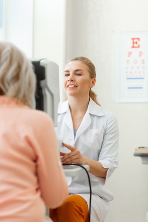 Visual inspection. Beaming positive doctor dealing with complicated computer technologies while observing monitorの写真素材