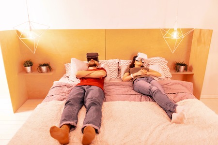 Weekend. Young tired couple resting while laying on the bed together