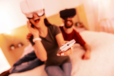 Good day. Excited high-spirited man and woman playing virtual games while being at homeの写真素材
