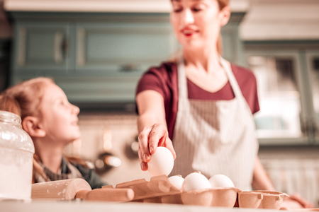 Just look. Attentive girl raising head while staring at her mommyの写真素材
