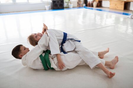 Aikido lesson. Dark-haired boy attacking girl while having aikido lesson at the weekendの写真素材