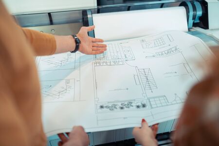Analyzing sketches. Top view of two talented interior designers analyzing sketches togetherの写真素材