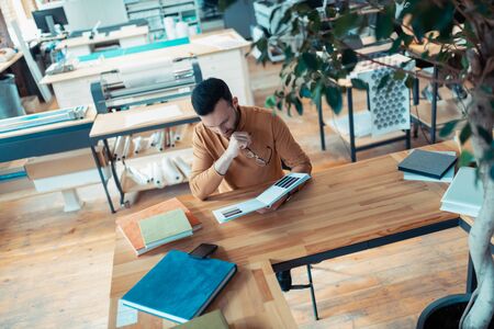 Graphic designer. Bearded handsome graphic designer working in publishing office choosing the colorの写真素材