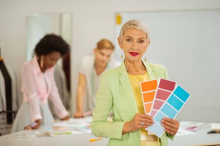 Color samples. Closeup portrait of a senior female fashion designer standing in a workshop while holding color samplesの写真素材