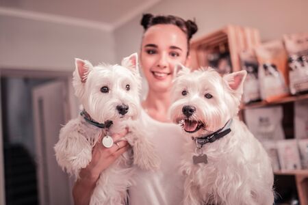 Young woman smiling. Beautiful young woman smiling while spending time with her cute dogsの写真素材