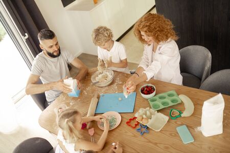 United family. Top view of a happy nice family with kids while cooking together in the kitchenの写真素材