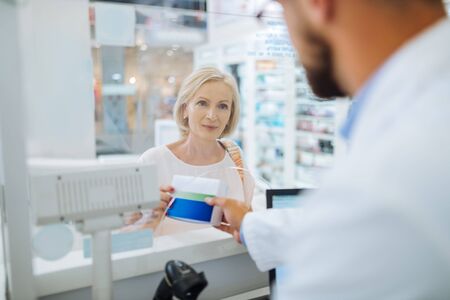 Good afternoon. Cute senior woman expressing positivity while communicating with pharmacistの写真素材