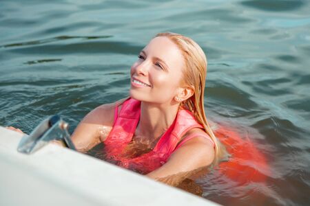 Happy smile. Closeup portrait of a smiling good-looking Caucasian blonde woman in her 30s leaning on...