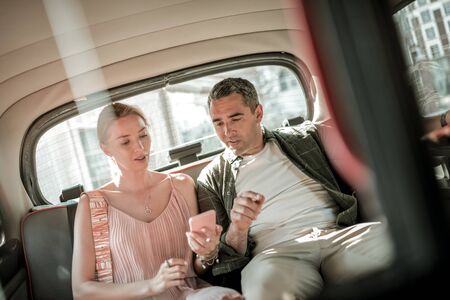 Going to the date. Smiling married couple looking at their destination point on the smartphone map...
