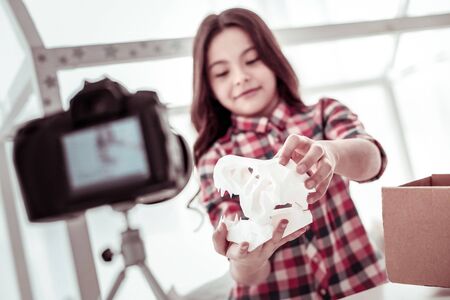 Sharp teeth. Selective focus of a dinosaur skull model being in hands of a nice young girlの写真素材