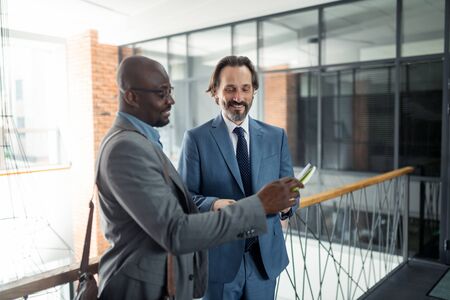 Businessmen smiling. Two businessmen smiling while feeling excited and motivated before negotiationの写真素材
