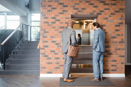 Businessmen entering lift. Two prosperous successful businessmen entering lift in the business centerの写真素材
