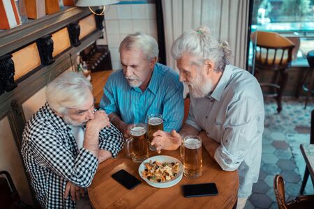 Unhappy after football. Top view of retired man feeling unhappy after watching footballの写真素材