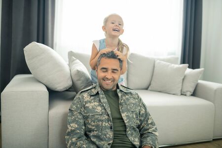 Military officer smiling. Military officer smiling while finally spending time with his cute daughterの写真素材