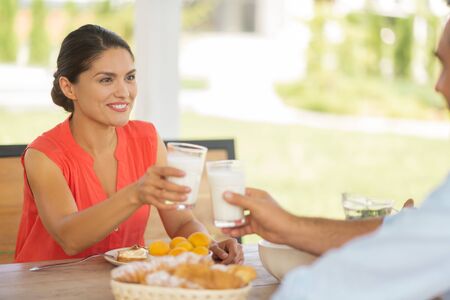 Couple drinking yoghurt. Couple drinking yoghurt in the morning while having breakfast outside togetherの写真素材
