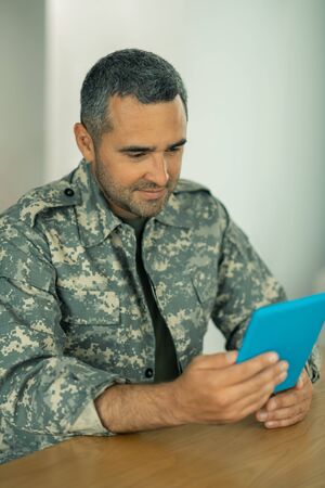 Online video chat. Handsome bearded military officer having online video chat with wifeの写真素材