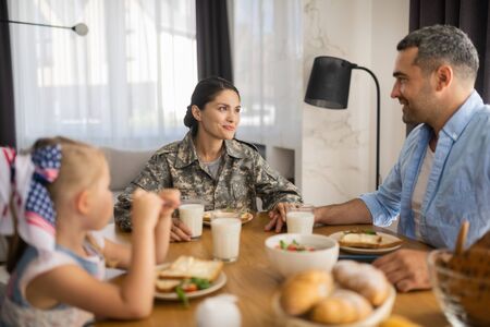 Beautiful female soldier. Beautiful female soldier spending morning with husband and daughterの写真素材