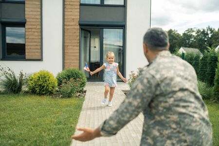 Girl running. Girl wearing summer dress feeling amazing leaving house and running to fatherの写真素材