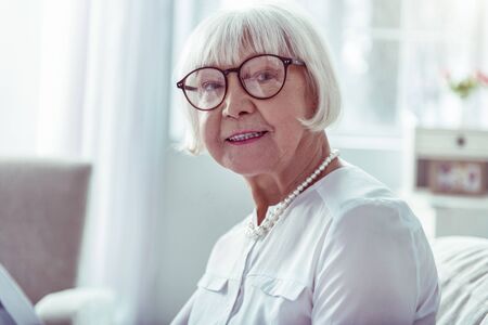 Beaming lady. Close up of beaming elegant elderly lady smiling broadly after amazing family dayの写真素材
