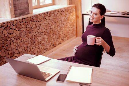 Just look. Charming brunette expressing positivity while drinking teaの写真素材