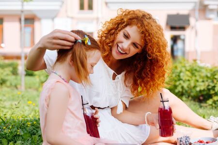 My princess. Pretty red haired woman expressing positivity while looking at her kidの写真素材