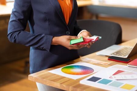 Holding color palette. Close up of interior designer holding color palette while planning project
