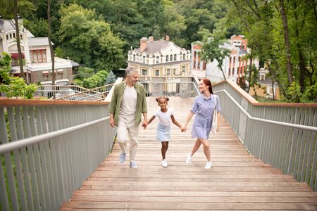 Family walking upstairs. Happy family walking upstairs in the park while spending time togetherの写真素材