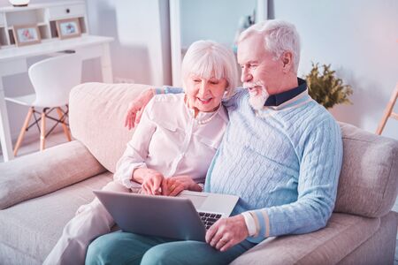 Modern grandparents. Modern beaming grandparents having video chat with their grandchildren using...