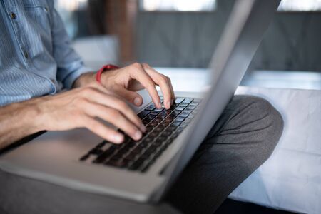 Freelancer working hard. Close up of freelancer typing on laptop and working hard while having too...
