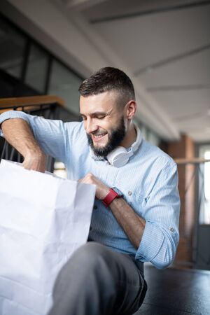 Food delivery. Dark-haired man wearing smart watch smiling after using food deliveryの写真素材