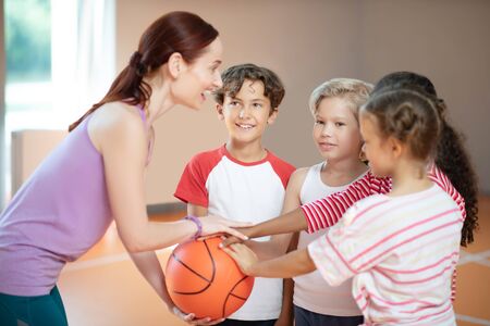 Before basketball game. PE teacher and children smiling before starting basketball game at PE classの写真素材
