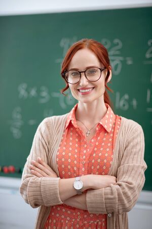 Teacher wearing glasses. Stylish experienced teacher wearing glasses smiling while feeling excited