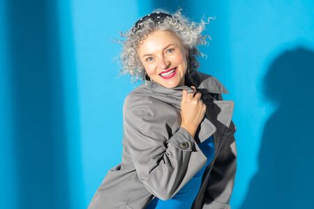 Cheerful and happy. Beaming blue-eyed woman with curly hair feeling cheerful and happyの写真素材