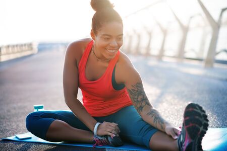 Doing yoga outside. Smiling woman feeling amazing while doing yoga outside at the weekend