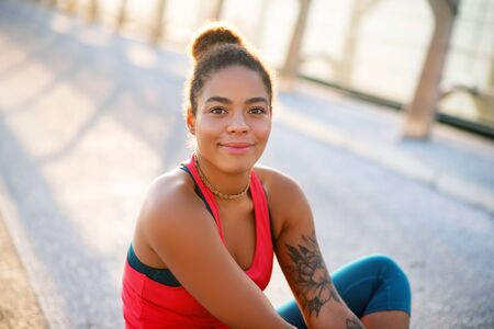 Dark-eyed woman. Dark-eyed beautiful woman with tattoo on arm feeling amazing after yogaの写真素材