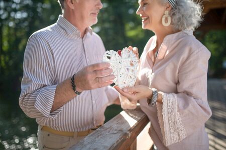 Beaming couple.Close up of beaming couple holding amazing handmade heart in their hands
