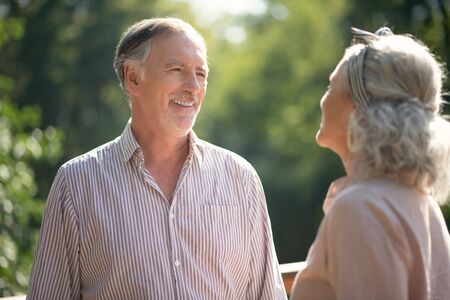 Man laughing, Grey-haired bearded man laughing while talking to wife and walking together