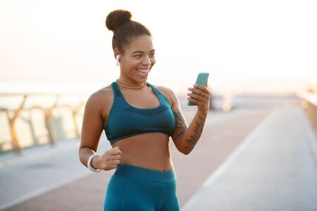 Reaching target weight. Dark-eyed woman feeling satisfied after reaching target weight while using...