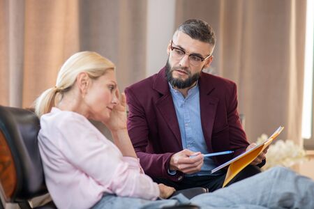 Bearded psychoanalyst. Bearded professional psychoanalyst in glasses listening to patientの写真素材