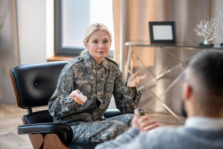 Attending psychologist. Blonde military woman feeling better while attending psychologist regularlyの写真素材