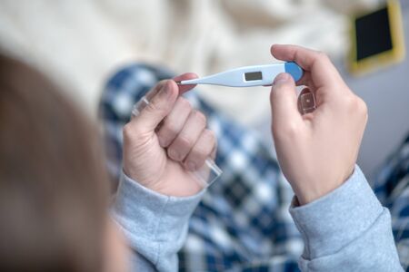 Man taking thermometer. Top view of sick mature man taking thermometer while feeling hot