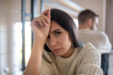 Wife having headache. Close up of dark-eyed wife having headache after disagreement with husbandの写真素材