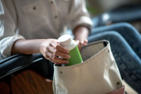 Antidepressants into bag. Close up of woman putting antidepressants into bag after talking to psychologistの写真素材
