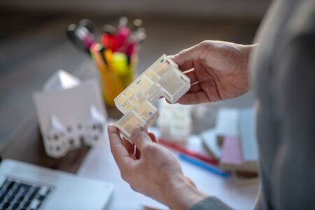 Holding apartment model. Top view of interior designer holding apartment model while planning projectの写真素材