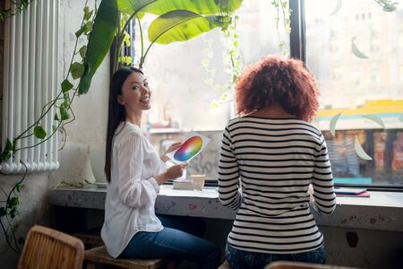 Two fashion designers. Two fashion designers creating new project having discussion in cafeteriaの写真素材